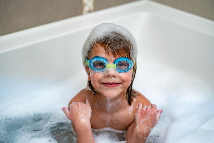 A child in a bathtub with goggles